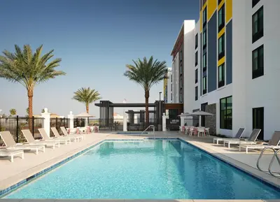 a swimming pool with lounge chairs and a building at Hilton Garden Inn Merced in Merced