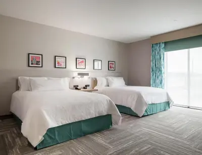 a hotel room with two beds and a window at Hilton Garden Inn Merced in Merced
