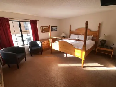 a bedroom with a bed and a chair and a window at Rr-interlaken 09 in June Lake