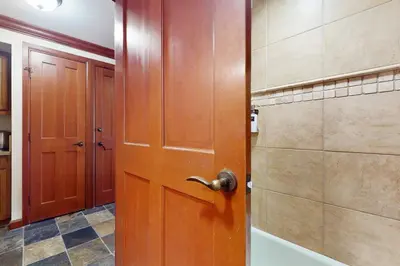 a bathroom with a wooden door and a shower at Everline Resort & Spa 630 in Olympic Valley