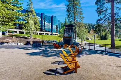 a group of wooden chairs sitting in a park at Everline Resort & Spa 630 in Olympic Valley