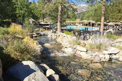 a stream of water with rocks and a swimming pool at Everline Resort & Spa 317 in Olympic Valley