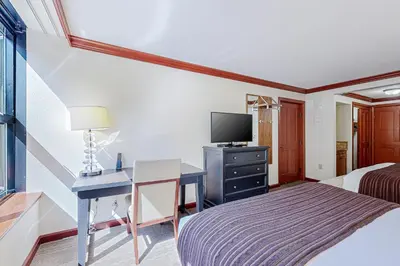 a hotel room with a bed and a desk and a tv at Everline Resort & Spa 523 in Olympic Valley