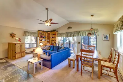 a living room with a blue couch and a table at Quiet Truckee Retreat with Deck, 5 Mi to Donner Lake in Truckee