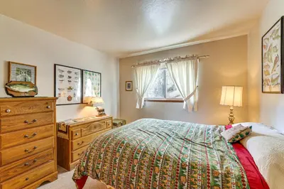 a bedroom with a bed and a dresser and windows at Quiet Truckee Retreat with Deck, 5 Mi to Donner Lake in Truckee