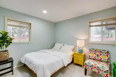 a bedroom with a bed and a chair and windows at Work and Play! Lake Tahoe Cabin 5 Mi to Heavenly Mtn in South Lake Tahoe