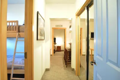 a hallway leading to a bedroom with a bunk bed at Juniper Springs Lodge # 203 in Mammoth Lakes