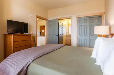 a bedroom with a bed with a dresser and a television at Sunstone # 329 in Mammoth Lakes