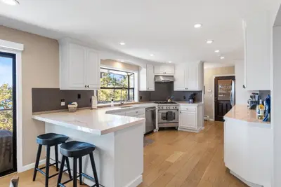 a kitchen with white cabinets and bar stools at HCH0868 - The Grand Escape home in South Lake Tahoe