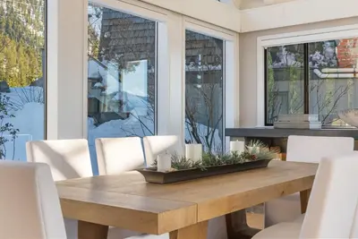 a dining room with a wooden table and white chairs at HCH0868 - The Grand Escape home in South Lake Tahoe