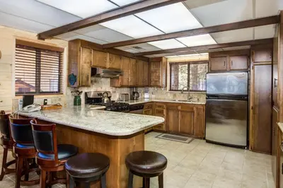 a kitchen with wooden cabinets and a kitchen island with bar stools at 42A Megan in North Wawona