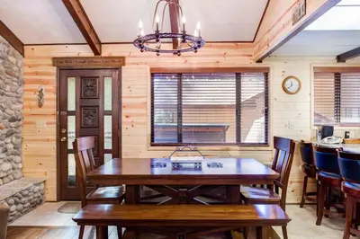 a dining room with a wooden table and chairs at 42A Megan in North Wawona