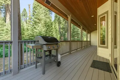 a screened in porch with a grill on it at Leisure Landing Unwind in the Pines in Shaver Lake