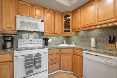a kitchen with white appliances and wooden cabinets at Tahoe Keys Townhouse with Boat Dock in South Lake Tahoe