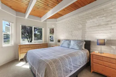 a bedroom with a bed and two windows at Tahoe Keys Townhouse with Boat Dock in South Lake Tahoe