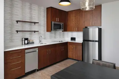 a kitchen with wooden cabinets and a stainless steel refrigerator at Residence Inn by Marriott Reno South in Reno