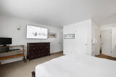 a bedroom with a bed and a dresser and a television at 3 Bedroom Kirkwood Condo – Base Camp condo in Kirkwood