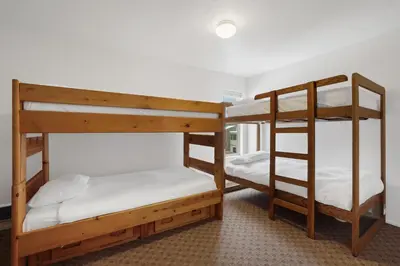 two bunk beds in a room with white sheets at 3 Bedroom Kirkwood Condo – Base Camp condo in Kirkwood