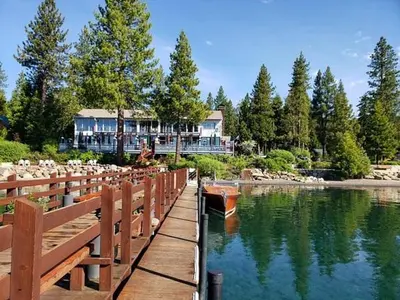 a wooden bridge over a river with a house in the background at Jester Court home in Tahoe Vista