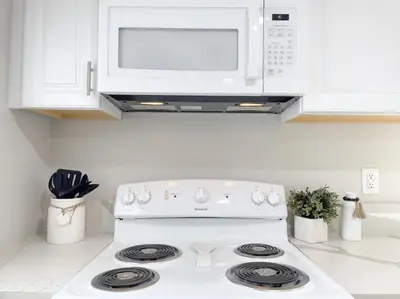a white stove top oven in a kitchen with a microwave at Country Living 3BR with fenced yard on Mooney in Visalia