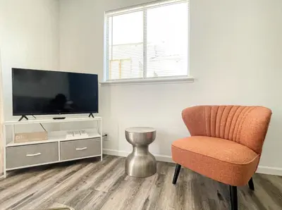 a living room with a chair and a flat screen tv at Lovely home central Coalinga-2BR Stopover near I-5 in Coalinga