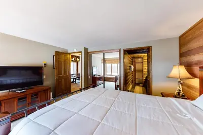 a bedroom with a large white bed and a television at Sierra Megeve 6 in Mammoth Lakes