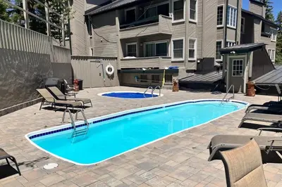 a swimming pool with chairs and a house at Sierra Megeve 6 in Mammoth Lakes