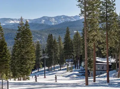 a snow covered slope with trees and a ski lodge at Northstar Ski-In Ski-Out Luxury Townhome with Hot Tub in Truckee