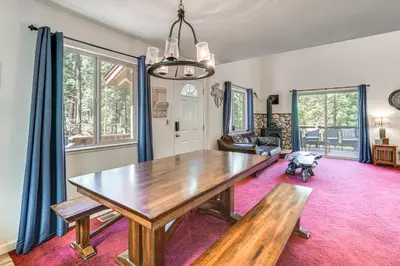 a dining room with a wooden table and blue curtains at Hike, Swim, Golf Family Retreat in Arnold! in Arnold