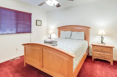 a bedroom with a wooden bed and a dresser and a window at Hike, Swim, Golf Family Retreat in Arnold! in Arnold