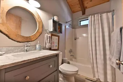 a bathroom with a sink and a toilet and a mirror at Cozy Chic Chalet - Enchanting & Fun Family Retreat - Hot Tub & Fire Pit - Dog Friendly in Dorrington