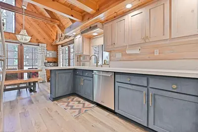a kitchen with blue cabinets and a wooden ceiling at Cozy Chic Chalet - Enchanting & Fun Family Retreat - Hot Tub & Fire Pit - Dog Friendly in Dorrington