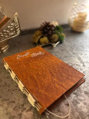 a brown notebook sitting on top of a table at Cozy Chic Chalet - Enchanting & Fun Family Retreat - Hot Tub & Fire Pit - Dog Friendly in Dorrington