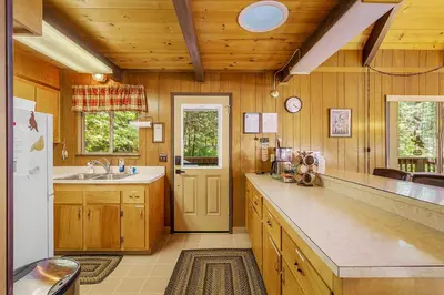 a kitchen with a sink and a refrigerator at Walk to Fly-In Lake Blue Lake Springs Cabin! in Arnold