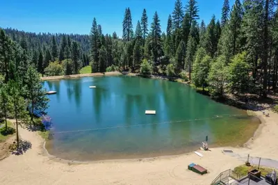 an aerial view of a large lake in the woods at Walk to Fly-In Lake Blue Lake Springs Cabin! in Arnold