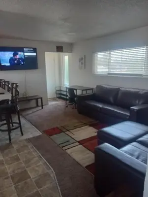 a living room with a couch and a flat screen tv at Franklin Apt in Fresno
