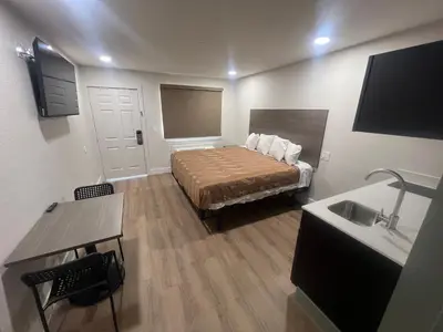 a small room with a bed and a sink at Value Suites Extended Stay in Sacramento