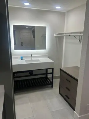 a bathroom with a white sink and a mirror at Value Suites Extended Stay in Sacramento