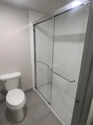 a bathroom with a toilet and a glass shower at Value Suites Extended Stay in Sacramento