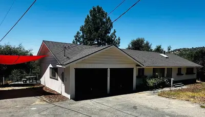 a house with a garage with a red flag on it at Fun for 2-Hot Tub-Dogs Ok-Near Bass Lake in Oakhurst