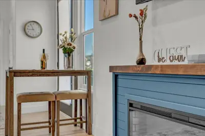 a living room with a blue fireplace and a table at Peaceful Guest Casita with Private Entrance and No Cleaning Fee in Hanford