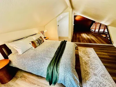 a bedroom with a bed in a room with a staircase at The Falls-Overlooks a waterfall-BBQ-Sleeps 4 in Oakhurst