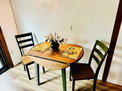 a dining room table with a vase of flowers on it at The Falls-Overlooks a waterfall-BBQ-Sleeps 4 in Oakhurst