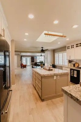 a large kitchen with white cabinets and granite counter tops at Villa Luxury Family Getaway in Patterson