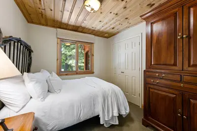 a bedroom with a white bed and a wooden ceiling at Luxury 4BR Retreat Near Northstar Sleeps 10 in Tahoe Vista