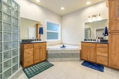 a bathroom with a tub and two sinks and a large mirror at The Blue Resort of Yosemite - Pool, Spa, Games in Mariposa