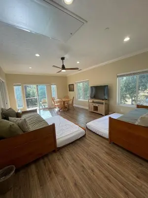 a bedroom with two beds and a flat screen tv at Beautiful Lake Views with Hot Tub and Space for Family in Oakhurst