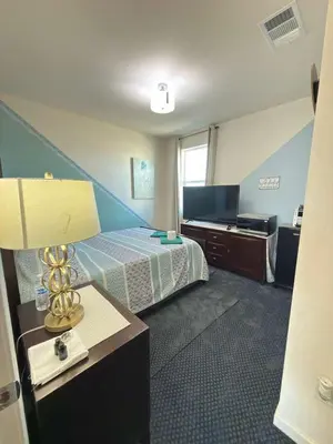 a hotel room with a bed and a desk with a lamp at Peaceful Private Room in Sparks in Sparks