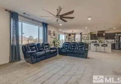a living room with blue chairs and a ceiling fan at Peaceful Private Room in Sparks in Sparks