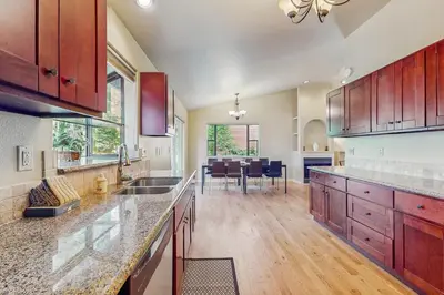 a large kitchen with wooden cabinets and a dining room at My Tahoe Sanctuary in South Lake Tahoe